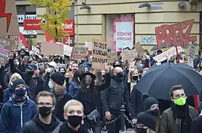 A large crowd of protesters holding signs promoting women's rights in Polish