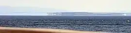 Distant shadowy appearances of land, seen across a wide expanse of sea