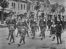 Soldiers marching along a city street