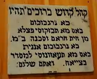 A wall sign advising attendants of a Jewish synagogue on what to do during prayer.