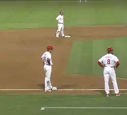 Runners on second and third base, with the third-base coach nearby