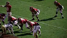 American football players in position prior to a snap.