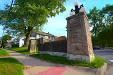 The entrance to the second phase of the Kensington Park Addition in the Kensington Boulevard Historic District on the south side of Lake Avenue is made of stone, in contrast to the entrance structures north of it, which are made of brick. Like its brick counterpart across the street, this entrance structure features globe streetlights.