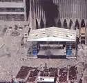 The last known photograph of the sculpture, seen on the far left, below the Marriott Hotel and in front of the 1993 World Trade Center Bombing Memorial, during the September 11th attacks.