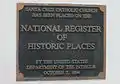 A  National Register of Historic Places marker on the wall at the front of the church.