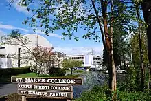 Photo of campus welcome sign with buildings in the background