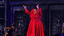 Photograph of a person on a stage wearing a red outfit